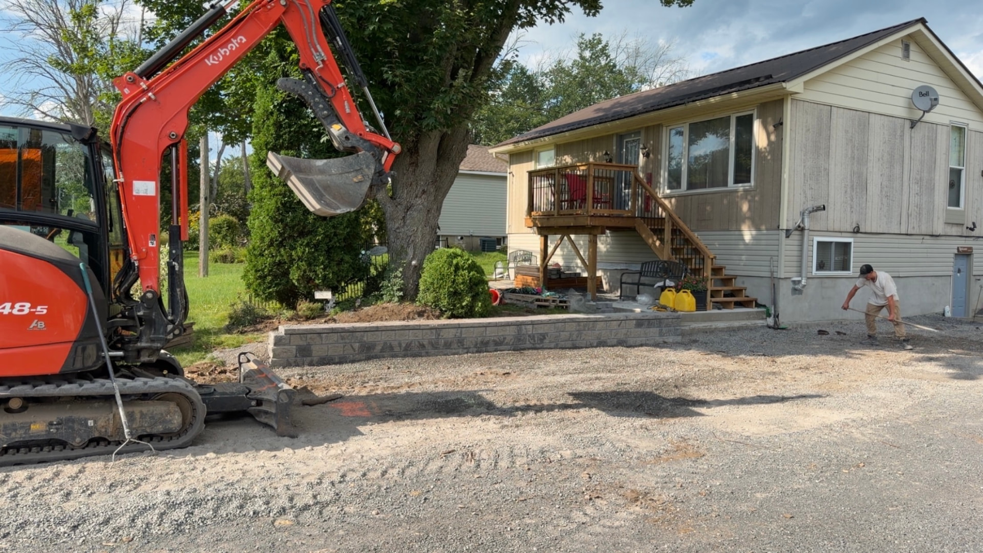Red Kubota excavator working on a residential excavation and grading project