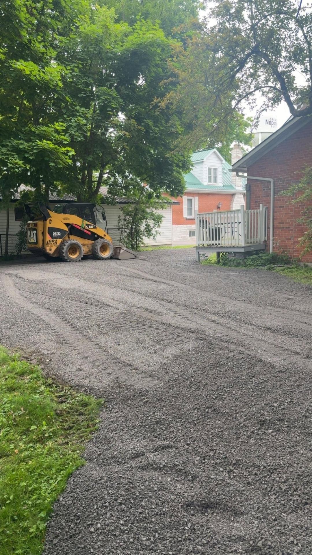 CAT skid steer grading a fresh gravel driveway