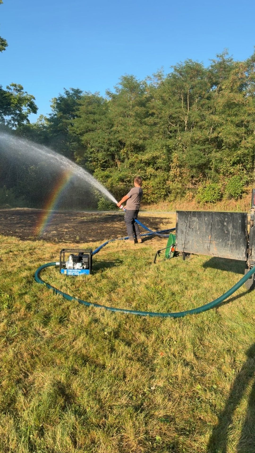Hydro-seeding a graded lot, rainbow catching in the spray